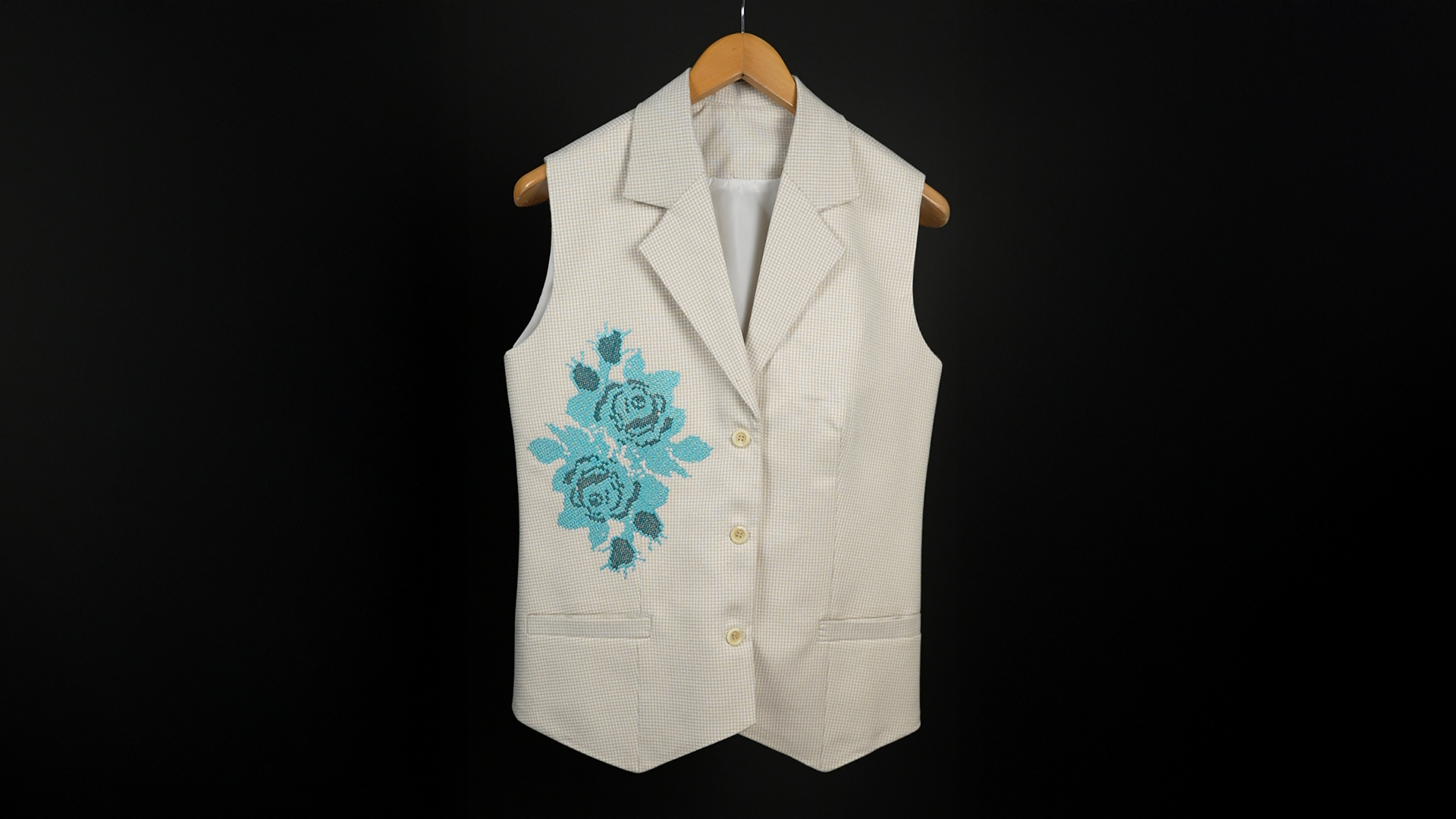 Sleeveless beige vest with blue floral embroidery on chest